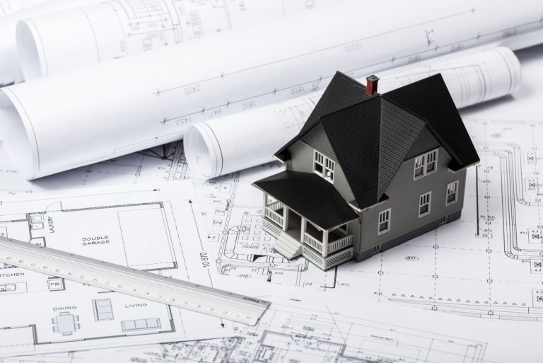 Discover the top reasons for planning permission refusal. Image depicts a miniature house on top of paper building plans.